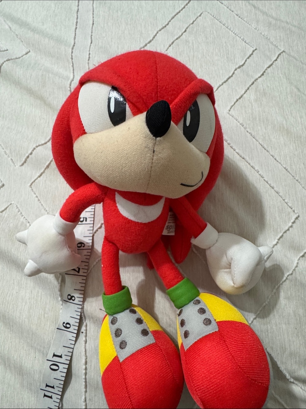 Red Plush Character Toy with Cream Face and Bright Yellow-Red Shoes